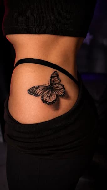 Motyl — Piękny realistyczny motyl na kobiecym biodrze.